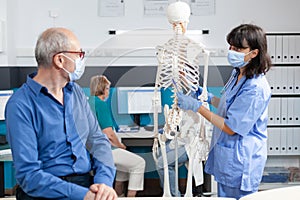 Retired man looking at human skeleton for chiropractic care