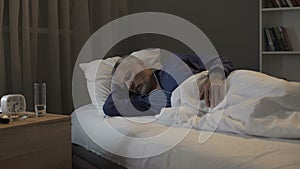 Retired man seeing nightmares in his dreams, sleeping in ward of nursing home