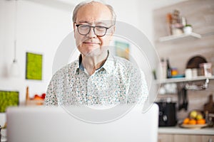 Retired man smiling while watching a movie