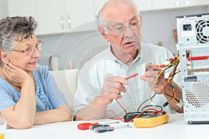 Retired man testing computer with multimeter