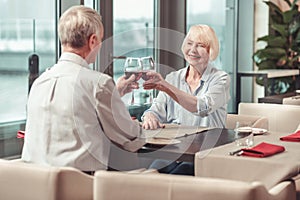 Retired man and woman drinking red wine together