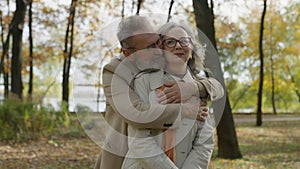 Retired mature old man hug woman from behind affectionate husband embrace wife cuddle romance tender relationship love