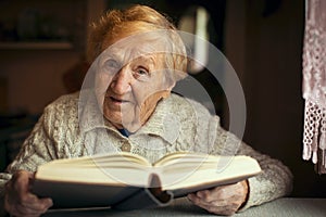 Retired old happy woman reading a book in your house.