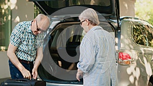 Retired people loading voyage baggage and trolleys inside vehicle