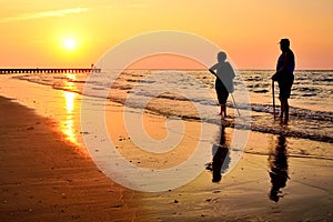 Retired people walking on the beautiful morning beach during sunrise