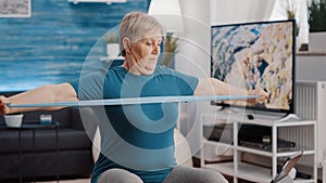 Retired person following workout video on tablet to exercise