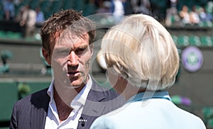 Retired player Pat Cash being interviewed by Sue Barker on centre court before the start of the men`s finals.