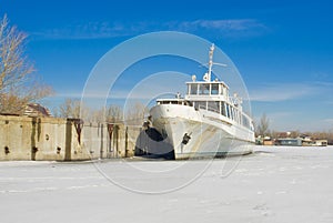 Retired pleasure boat on a winter river.