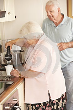 Retired Senior Couple In Kitchen Making Hot Drink Together