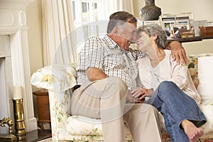 Retired Senior Couple Sitting On Sofa At Home Together