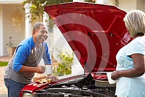 Retired Senior Couple Working On Restored Car photo