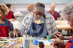 Retired Senior Man Attending Art Class In Community Centre