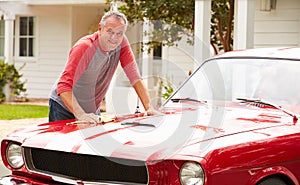 Retired Senior Man Cleaning Restored Classic Car