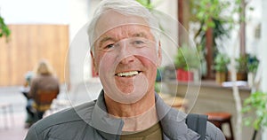 Retired senior man happily laughing after enjoying a coffee shop. Portrait of friendly pensioner enjoying life. Close up