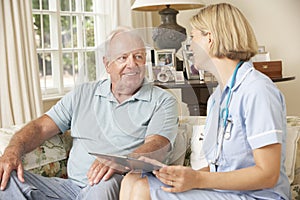 Retired Senior Man Having Health Check With Nurse At Home