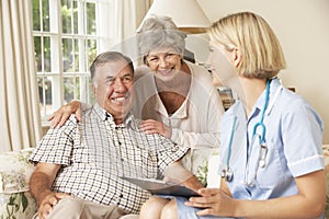 Retired Senior Man Having Health Check With Nurse At Home