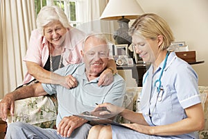 Retired Senior Man Having Health Check With Nurse At Home