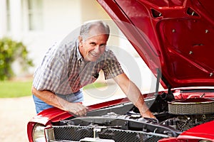 Retired Senior Man Working On Restored Car photo