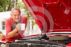 Retired Senior Man Working On Restored Classic Car