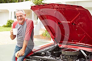 Retired Senior Man Working On Restored Classic Car