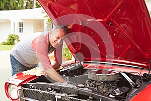 Retired Senior Man Working On Restored Classic Car