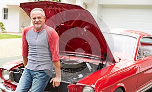 Retired Senior Man Working On Restored Classic Car