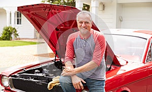 Retired Senior Man Working On Restored Classic Car