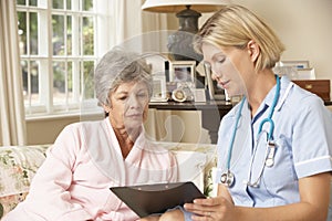 Retired Senior Woman Having Health Check With Nurse At Home