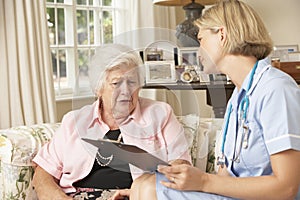 Retired Senior Woman Having Health Check With Nurse At Home