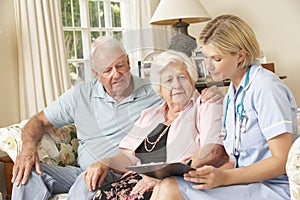 Retired Senior Woman Having Health Check With Nurse At Home