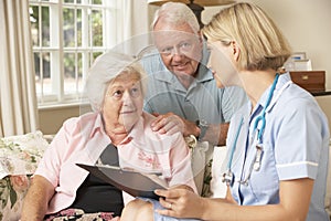 Retired Senior Woman Having Health Check With Nurse At Home