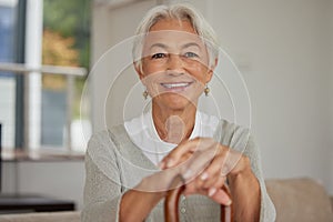 Retired senior woman relaxing at home. Happy smiling old woman holding walking cane and looking at the camera with