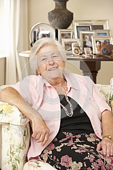 Retired Senior Woman Sitting On Sofa At Home