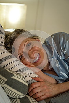 Retired smiling woman lying in bed