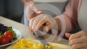 Retired woman cutting fresh vegetables, loving husband kissing wife, tenderness