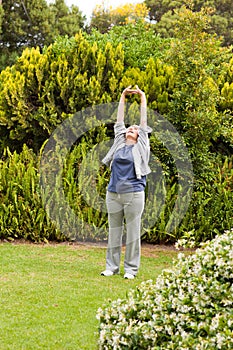 Retired woman doing her streches in the garden