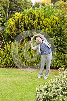Retired woman doing her streches in the garden