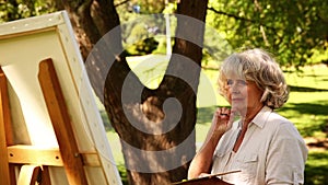 Retired woman painting outside