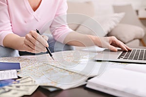 Retired woman planning her worldwide trip with map and laptop