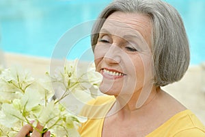 Retired woman posing with flowers