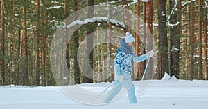 A retired woman rides very fast through the winter forest on classic skis