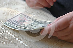 Retired woman with small amount of money on table, toned image, colorized, selective focus, very shallow dof. SEnior