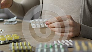 Retired woman taking pills with water, research focus group member, side effects