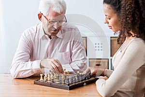 Retiree and caregiver playing chess