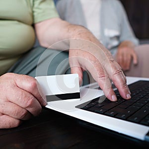 Retiree couple shopping online using laptop