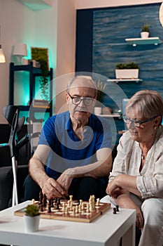 Retirement aged people sitting on living room sofa