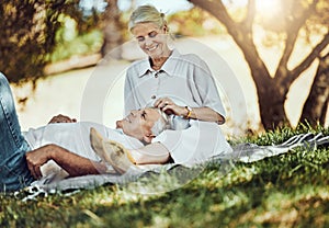 Retirement, love and picnic with a senior couple outdoor in nature to relax on a green field of grass together. Happy