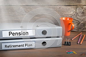 Retirement Plan and Pension - two folders on wooden office desk