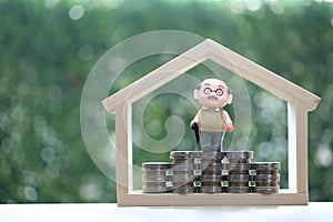 Retirement planning, Seniorman standing on stack of coins money on natural green background, Save money for prepare in future and