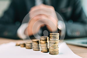 Retirement saving plant concept, businessman with coin stack on office desk